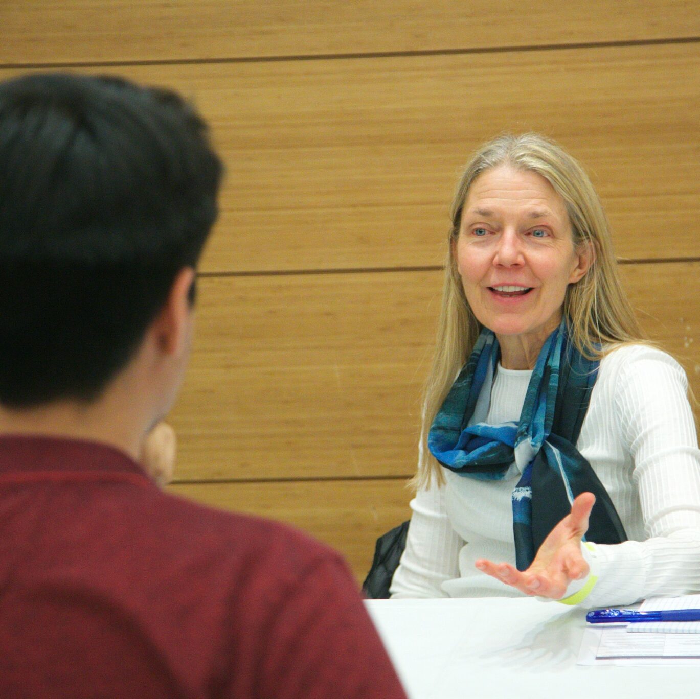 Advisor speaking with a student during a session at a white table